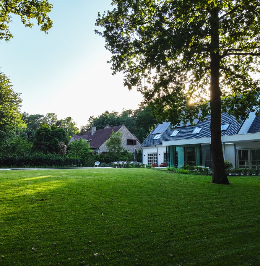 onderhoudsvriendelijke tuin met robotmaaier en modern landhuis
