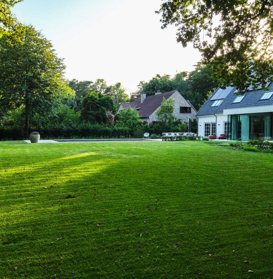 grote tuin met modern huis en zwembad in avondzon